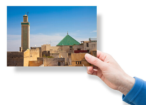 Hand holding an postcard about the most important religious complex of the medieval medina of Fes with the Zawiya of Moulay Idriss II and the ancient minaret (Africa - Morocco)