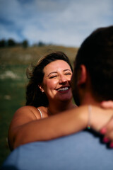 Fototapeta premium Happy Young Woman Hugging Her Partner Outdoors - Joyful Moment and Genuine Smile