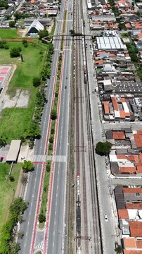 Vis&atilde;o a&eacute;rea da passagem de trem na cidade de Mogi das Cruzes, destacando a linha f&eacute;rrea, a integra&ccedil;&atilde;o urbana e o transporte ferrovi&aacute;rio na regi&atilde;o.