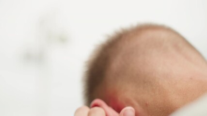 white man cleaning hearing device closeup, intimate bathroom setting, mirror reflection hinted, fingers removing wax and securing receiver, glasses slid down nose, gentle movements for hygiene