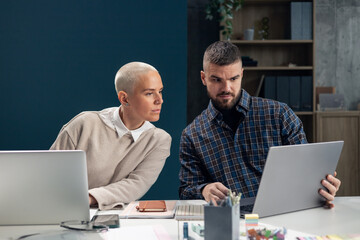 Colleagues collaborating on laptop during office meeting