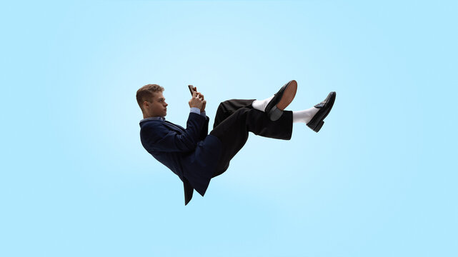 Business man levitating while reading smartphone notifications. Concept of startup operations, task alerts, product updates, sprint coordination, fast decision making and real time team management.