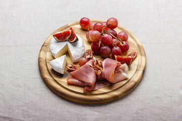 Charcuterie board with meat, cheese, grapes, nuts and fresh figs.