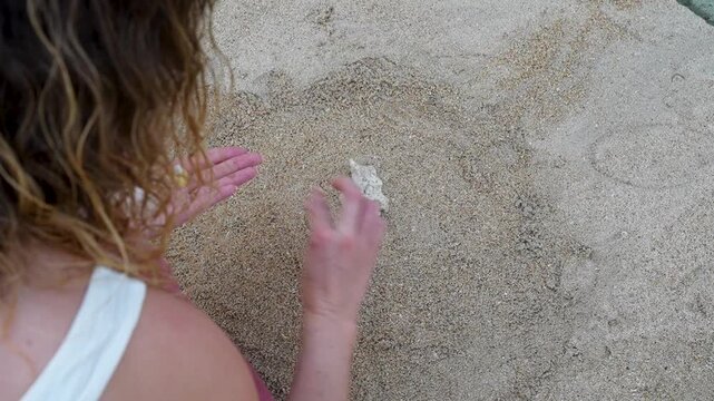 Woman Creating a Small Grave for Deceased Pet on Sandy Beach, Top View