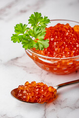 Salmon  caviar and parsley with metal spoon vertical composition