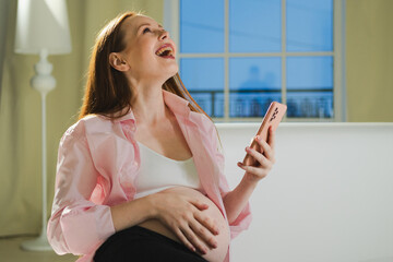 Pregnancy motherhood. Pregnant woman with smartphone typing scrolling at home. Woman with cell phone enjoying pregnancy surfing internet using social media apps. Mobile application for pregnant women
