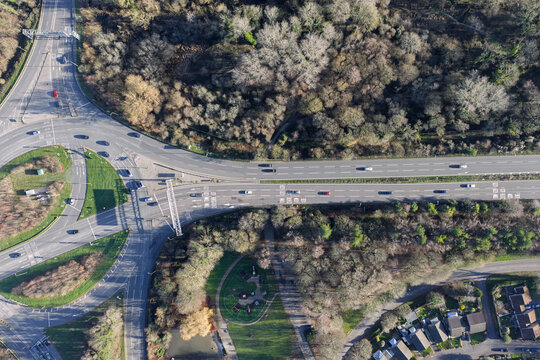 Aerial view of roads curving through a landscape of contrasting green grass and trees, with buildings visible, Basingstoke, England, United Kingdom.