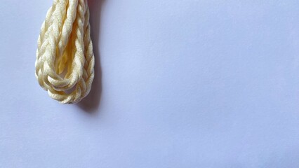Cream colored fiber ropes are arranged in circles on a clean white background, showcasing a minimalist concept, textured details, and empty space.