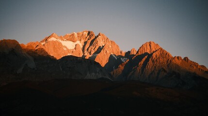 Sunrise Glow on Jade Dragon Snow Mountain over Lijiang Old Town, Yunnan, China. © Jean