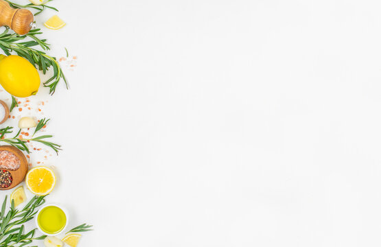 Fresh lemon rosemary and spices frame on white background with copy space