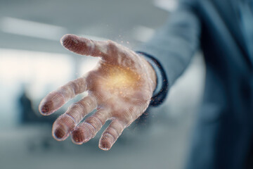 Business person extending a futuristic digital mesh hand emitting glowing particles symbolizing innovation and advanced technology in a modern office environment