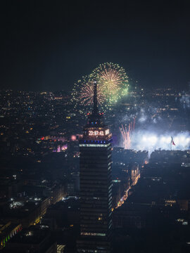 Aerial view of the Torre Latinoamericana illuminated against a backdrop of vibrant fireworks painting the dark sky with fleeting bursts of color, Mexico City, Mexico.