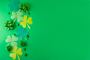 Shamrock saint patrick's day bright high-colored background, St. Patrick's holiday flatlay with party gift boxes, decor, shamrock and gold coins on green background