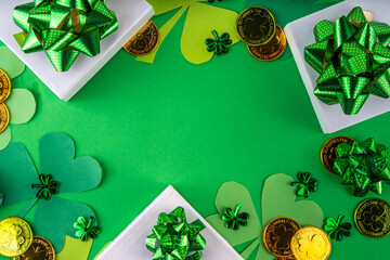 Shamrock saint patrick's day bright high-colored background, St. Patrick's holiday flatlay with party gift boxes, decor, shamrock and gold coins on green background