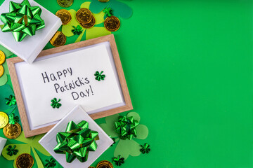 Shamrock saint patrick's day bright high-colored background, St. Patrick's holiday flatlay with party gift boxes, decor, shamrock and gold coins on green background