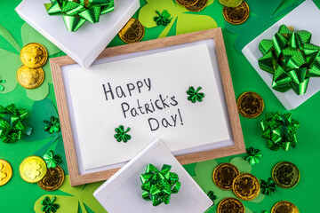 Shamrock saint patrick's day bright high-colored background, St. Patrick's holiday flatlay with party gift boxes, decor, shamrock and gold coins on green background