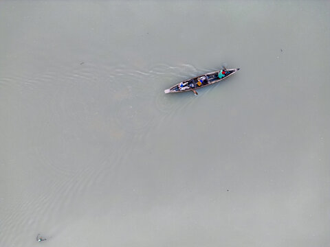 Aerial view of a small boat sailing on the water, the texture of the water contrasting with the crisp outline of the boat, Kaduna, Kaduna, Nigeria.