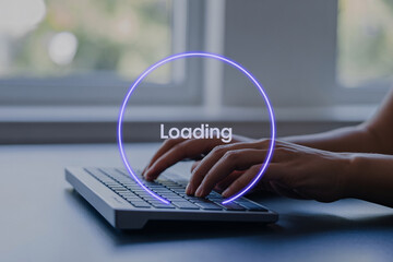 Person typing on laptop with loading animation on screen