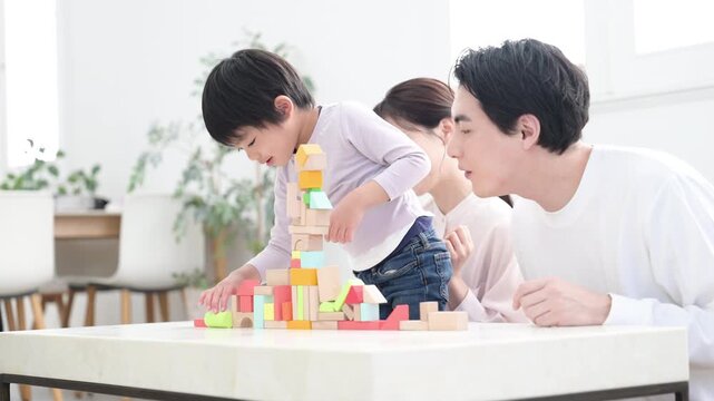 子どもの好奇心やチャレンジなどを家族で育てるイメージ　体験で非認知能力を伸ばそう！やったー！できたを褒める喜ぶ両親　積み木を積む