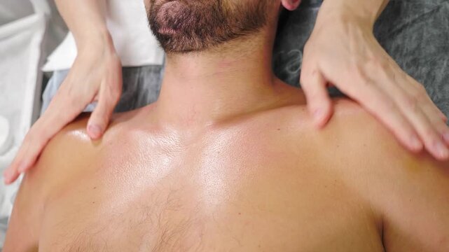 Massaging chest muscles of muscular athlete after workout. Sportsman receiving electric lift massage at spa salon. male client getting shoulders and neck massage. full body massage, Spa, cosmetology