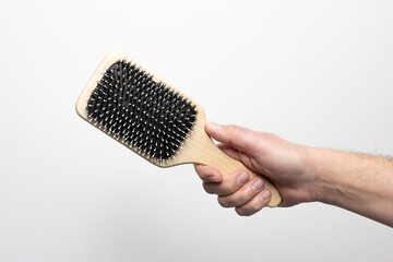 Obraz premium Męska dłoń trzymająca szczotkę do włosów