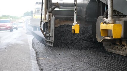 Special machinery making road in countryside area. Compactor constructing highway. Heavy machinery repairing road. Slowly driving roller laying new asphalt layer. Roadwork process. Roadway repair