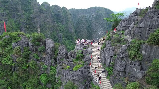Cinematic Drone Ascent over Mua Cave Viewpoint with Tourists at the Summit Hoa lu Ninh Binh Vietnam