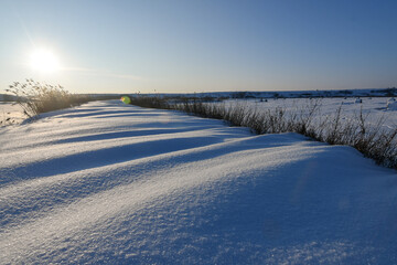 Winter Snowdrifts in Open Landscape at Sunrise