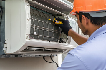Technician performing technical repair on air conditioner unit, wearing safety gloves and helmet, demonstrating expertise in HVAC maintenance and ensuring optimal performance of cooling systems
