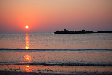 Die Sonne steigt aus dem Meer und f&auml;rbt den Himmel rosa.