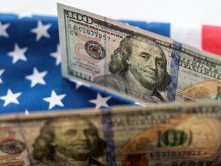 U.S. One Hundred Dollar Bill Over American Flag