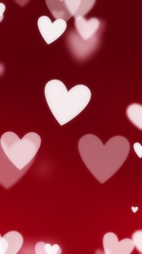 White and pink hearts floating on soft red background for Valentine's day. Heart particles fading in and out for a smooth romantic theme celebrating love, passion, or for a Valentines day background.