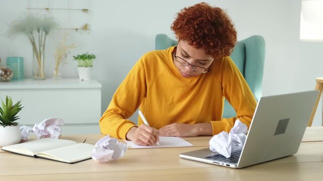 Serious african woman with crumpled paper having problem writing by hand document studying learning at home. Girl no idea sitting at workplace writing notes at office. Start up business deadline