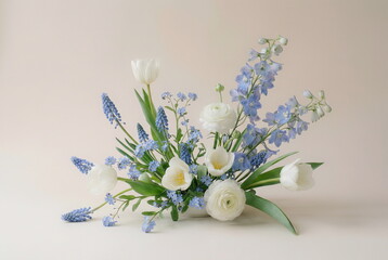 Flowers background. Beautiful arrangement of white and blue spring flowers in white vase on light beige background with copy space. Floral card