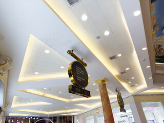 Naklejka premium Interior shopping mall ceiling with warm lighting and decorative sign in Manchester UK