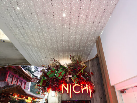 Christmas decor and Nichi neon sign at Manchester venue with gifts and festive greenery