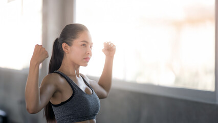 A beautiful young woman with a smiling face is in a gym. The concept is about exercise and health care. (Horizontal and vertical images available).