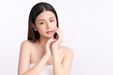 A beautiful young Asian woman with clean, fresh skin against a white background. Skincare, facial treatment, cosmetology, beauty, and spa. An elegant portrait of an Asian woman.