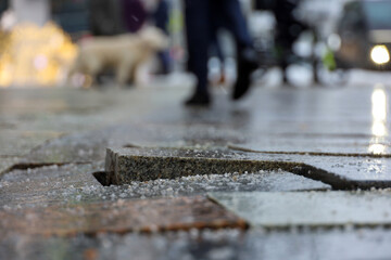 Cobbled city street in winter. Stone tiles sprinkled with deicing mixture