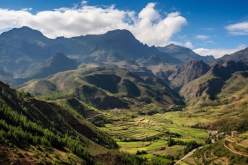 Obraz premium Green agricultural terraces shaping a rural valley with imposing mountains and a small village