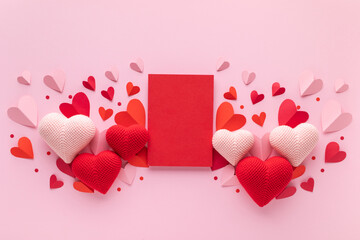 Saint Valentine or Mother's Day pink background with paper card blank and craft hearts top view and flat lay.