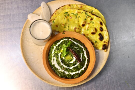 Makke ki roti sarso ka saag with buttermilk garnished with cream and butter