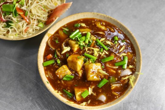 Paneer manchurian with fried rice indo chinese dish garnished with spring onions 