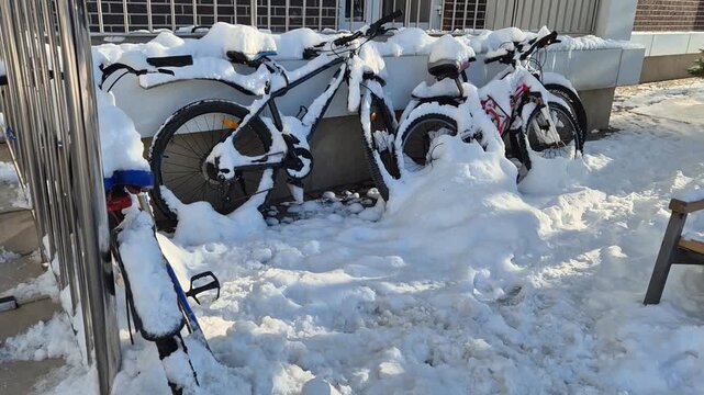 Bicycles left at the entrance covered in snow