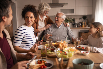 Multi-generational family members enjoying lunch together at home