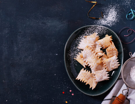 Italian carnival fritters dusted with powdered sugar. Selective focus. With free text space.