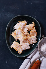 Italian carnival fritters dusted with powdered sugar. Selective focus. With free text space.