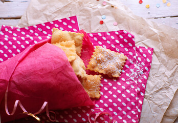 Italian carnival fritters dusted with powdered sugar. Selective focus. With free text space.