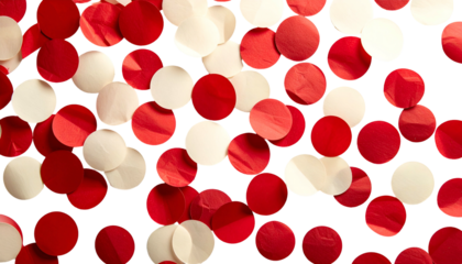 Overhead shot of scattered red and off-white circular paper pieces on a black background