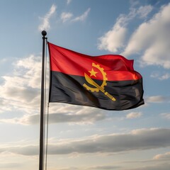The flag of Angola waving in the wind against a cloudy sky